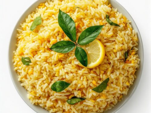Bright yellow lemon rice with peanuts and curry leaves, served on a banana leaf